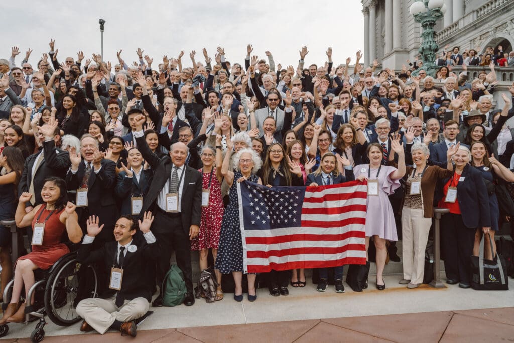 A large group of volunteers holding a flag in front of the Library of Congress in 2026