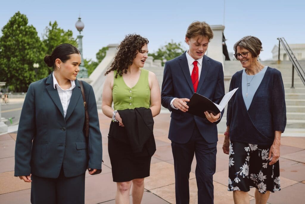 Volunteers walking at the capital looking at a folder of materials