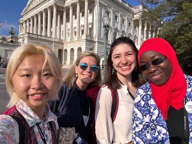 4 women of different ethnicities in front of a U.S. Capitol building